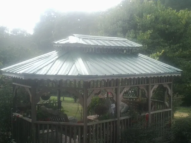 Two tier green metal roof on a garden gazebo in Norfolk